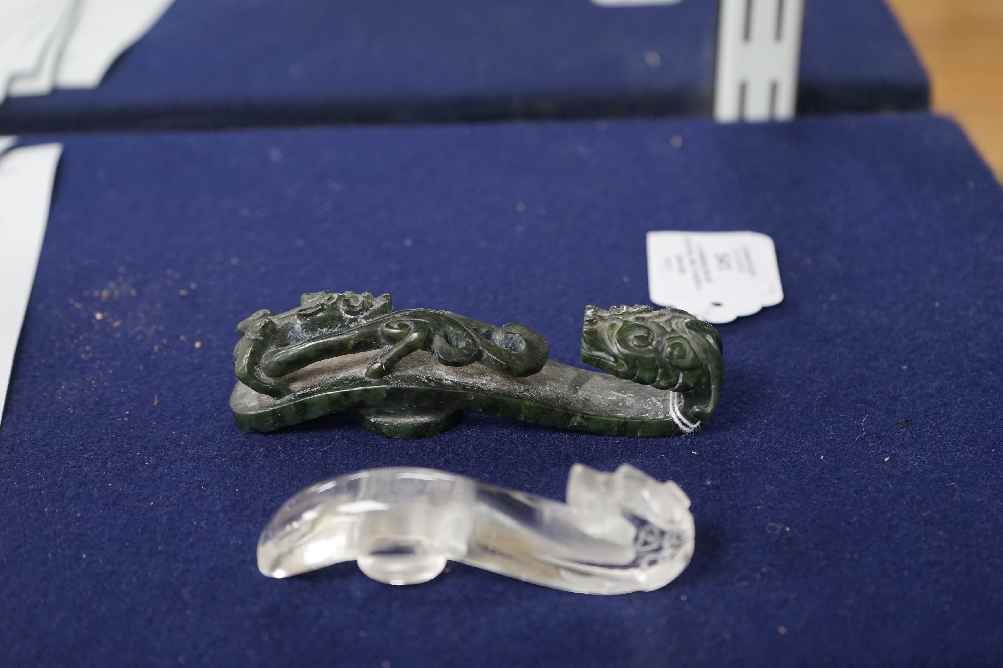 A Chinese rock crystal belt hook and a Chinese spinach green jade belt hook (2), largest 12cms long